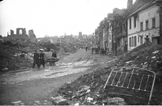 Photographie de maisons détruites sur la gauche de la route de Caen