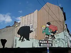 Photographie en couleur d'une fresque murale montrant les personnages de Quick et Flupke dans les rues de Bruxelles.