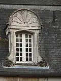 Fenêtre de toit surmontée d'une coquille.