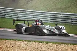 Photographie d'une voiture de sport-prototype noire, vue de trois-quarts avant, sur une piste.