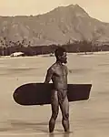 Surfer hawaïen avec planche alaia vers 1898