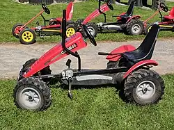 Kart à pédales à l'apparence d'un tracteur.