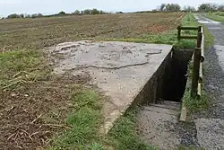 Photo d'un abris à munition à bordure d'un champ.