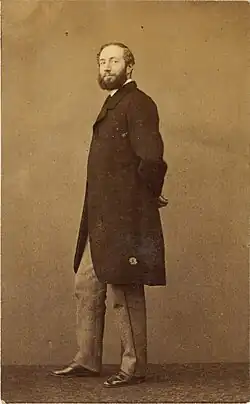 Photographie de Louis Morel Retz, qui pose de trois quarts en costume et regarde la caméra.