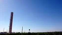 Vue d'un château-d'eau en forme de tour légèrement penchée à droite avec inscription Loving County.