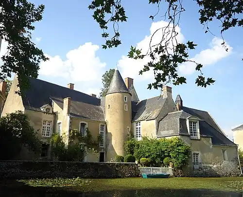 Photographie de l'extérieur d'un manoir entouré de douves.