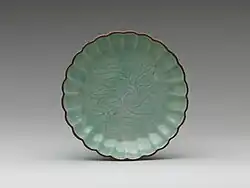 Assiette à bord festonné et à décor incisé sous couverte céladon. Porcelaine d'Arita ; type Imari, mi-XVIIe&nbsp;siècle (Metropolitan Museum of Art).