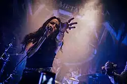 Chanteuse caucasienne sur scène derrière un micro.