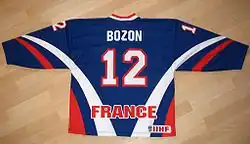 Photo du maillot bleu de l'équipe de France de hockey avec le numéro 12 et le nom de Bozon
