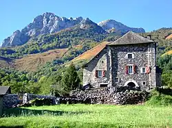 Vue sur une maison-forte à Borce, au milieu des montagnes.