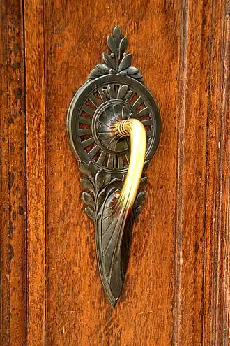 La poignée de porte.