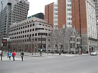 Photographie couleurs d'un complexe immobilier composé de bâtiments contemporains de différentes hauteurs avec un immeuble ancien en angle