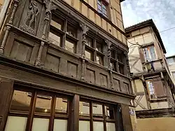 Photographie mettant en valeur la façade en bois sculpté de la maison de l'Homme des bois.