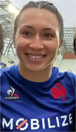 Jeune femme aux cheveux clairs plaqués, en maillot bleu de l'équipe de France.