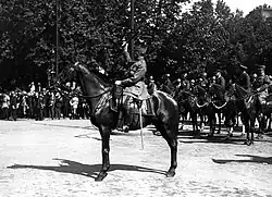 Le Maréchal Foch à cheval, saluant de son bâton lors du Défilé de la Victoire.