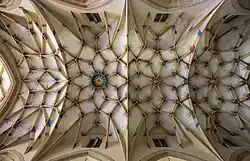 Un plafond blanc avec de nombreuses arcades ramifiées.