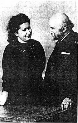 Photographie en noir et blanc d'une femme et d'un homme vêtu d'un costume.