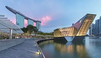 Panoramique de l'hôtel Marina Bay Sands et bâtiment éclairé Louis Vuitton à Marina Bay le soir avec des nuages roses, à Singapour. Juin 2018.
