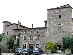 Porte fortifiée et vestige des remparts avec tour en poivrière.