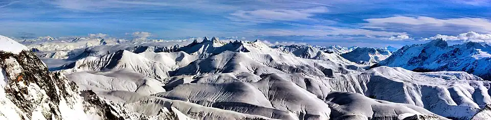 Vue depuis le massif des Grandes Rousses en direction de l'est avec les aiguilles d'Arves et l'aiguille du Goléon au centre et la Meije à droite.