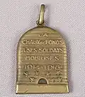 Médaille pendentif en laiton en forme de ruche. Ce souvenir de mobilisation des soldats chaux-de-fonniers pendant la Première guerre mondiale, comporte également des abeilles, symboles des habitants la Ville.