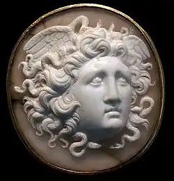 Dans un camée circulaire, tête de jeune femme de trois-quarts face avec une abondante chevelure où s'emmêlent de petits serpents. Elle a deux ailes sur les côtés de la tête.