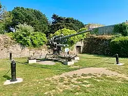Canon anti-aérien de 88 mm près du Mémorial 39-45. D’un poids total de 5 tonnes, manœuvré par 11 hommes, il disposait d’un plafond pratique d’utilisation de 8500 mètres et d’une cadence de tir de 15 à 20 coups par minute. Mis au point par l’Allemagne en 1928, il connaîtra différentes versions durant les années 1930 et 1940. De l’automne 1942 au printemps 1944, dans le cadre de l’édification du Mur de l’Atlantique, 6 exemplaires furent déployés sur le glacis du fort de la Cité d'Alet (emplacement de l’actuel camping) afin de protéger le chantier. Cet exemplaire est un don de la famille de Jacques Le Masson, président de la Société d’histoire et d’archéologie de l’arrondissement de Saint-Malo de 1984 à 1989.