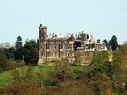 Photo d'un grand bâtiment aux murs gris sombre entouré d'arbres