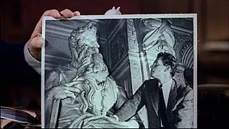 Cecil B. DeMille dans la bande-annonce du film, tenant une photo de Charlton Heston en train de regarder le Moïse de Michel-Ange. La ressemblance de l'acteur avec la sculpture l'a aidé à obtenir le rôle de Moïse.