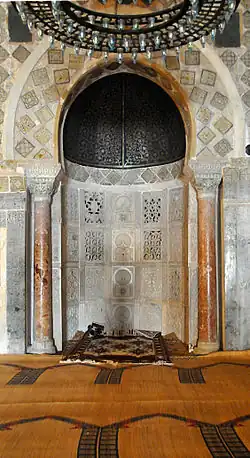 Mihrab de la grande mosquée de Kairouan (Tunisie). Il s'agit d'une niche en cul-de-four vide, encadrée de colonnes.