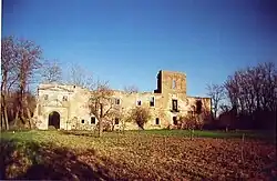 Photographie couleur d'un bâtiment en ruines au milieu des champs