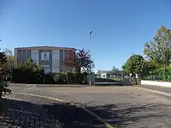 photographie en couleurs d'un complexe de bâtiments avec un portrait stylisé sur la façade de l'un d'eux.