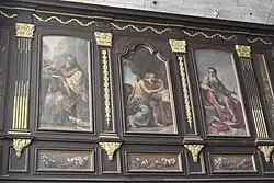 Lambris avec panneaux peints au-dessus des stalles.