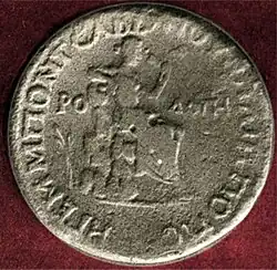 photographie d'une pièce de monnaie ; au centre une figure féminine assise