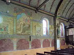 Photographie en couleurs de murs entièrement recouverts de peintures religieuses.