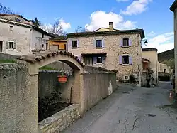 Photographie d'une rue de village avec maisons traditionnelles en pierre.