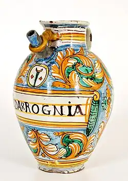 Verseuse à décor de spirales de feuilles échancrées, au-dessus l'emblème du cartouche médicinal de la béquille de l' hôpital Santa Maria Nuova, Montelupo Fiorentino, première moitié XVIIe&nbsp;siècle.