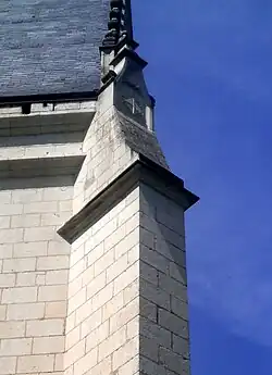 Vue d'un contrefort d'église surmonté d'une décoration de blasons.