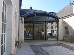 Photographie en couleurs d'un bâtiment moderne à la façade de verre.