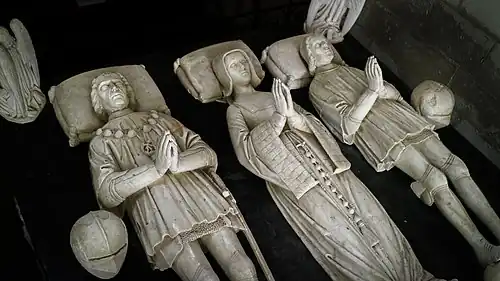 Vue plongeante sur les trois gisants en albâtre d'un tombeau.