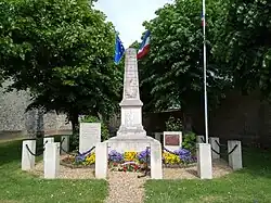 Monument aux morts de Chartainvilliers, présentant, sur la gauche, une stèle ainsi rédigée : « A la mémoire des officiers et soldats du 26e Régiment de Tirailleurs Sénégalais tombés sur le territoire de la commune en juin 1940. Ils sont 56 ! »