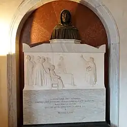 Tombeau en marbre blanc avec gravure surmontée d'un buste sculpté dans une niche à arcade