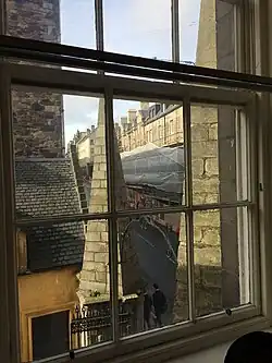 Photographie couleur d'une maison photographiée à travers une fenêtre