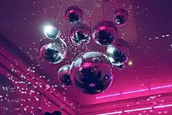 Photographie de boules à facettes suspendues à un plafond.