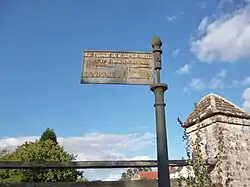 Ancien panneau de signalisation routière dans le village.