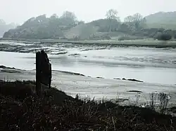 La rivière passe au milieu de larges vasières.