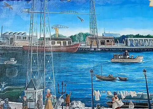 Le pont transbordeur, représenté sur Le Mur tombé du ciel. L'acrobate Willy Wolf y est représenté réalisant le plongeon qui lui est fatal le 31 mai 1925.