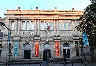 Photographie du musée d'aquitaine. Un grand bâtiment en pierre dont l'entrée est situé en haut d'un escalier.