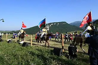 Groupe de cavaliers et de musiciens qui brandissent les drapeaux de l'Azerbaïdjan et de la Turquie