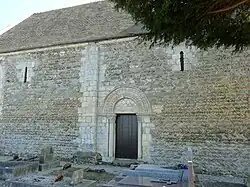 Mur nord de l'église de Mutrécy (Calvados), son portail et ses fenêtres du XIe&nbsp;siècle.